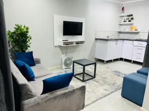 a living room with a couch and a tv at Reros Apartments in Mankweng in Mankweng