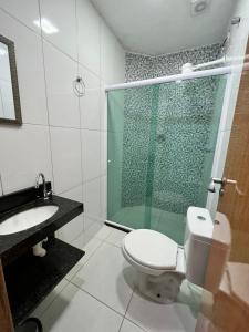 a bathroom with a shower and a toilet and a sink at Águas Rasas - Flats in Arraial do Cabo