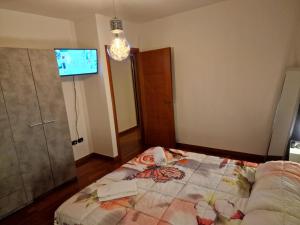 um quarto com uma cama e uma televisão na parede em Appartamento Vacanze Euganea em Rovolon