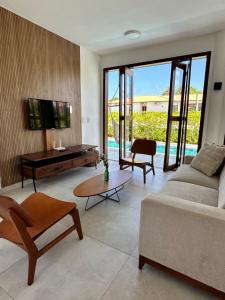 a living room with a couch and a table at Casa Ibiza - Pipa ''Luxurious 3-Bedroom Villa with pool'' in Pipa