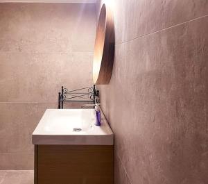 a bathroom with a sink and a light on a wall at Cozy Apartment in Korydallos in Piraeus