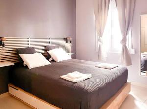 ピレウスにあるCozy Apartment in Korydallosのベッドルーム1室(大型ベッド1台、タオル2枚付)
