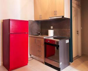 ピレウスにあるCozy Apartment in Korydallosのキッチン(赤い冷蔵庫、コンロ付)