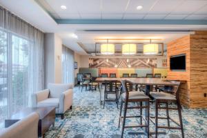 a waiting room with tables and chairs and a tv at Fairfield Inn & Suites by Marriott Winston-Salem Downtown in Winston-Salem