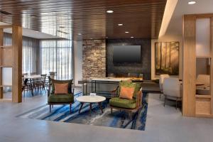 een lobby met stoelen en een tafel en een tv bij Fairfield Inn & Suites by Marriott Williamstown in Williamstown