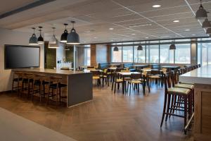 a restaurant with a bar and tables and chairs at Fairfield Inn & Suites by Marriott Williamstown in Williamstown
