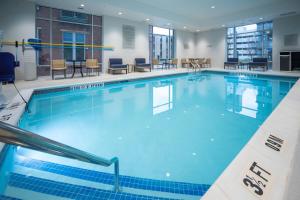 a large swimming pool with blue water at TownePlace Suites by Marriott Louisville Downtown in Louisville