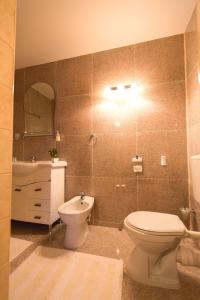 a bathroom with a toilet and a sink and a mirror at Noblesse Suite in Galaţi