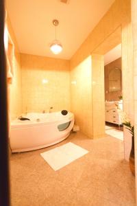 a large bathroom with a tub and a sink at Noblesse Suite in Galaţi