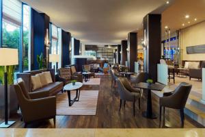 - un hall d'un hôtel avec des chaises et des tables dans l'établissement Sheraton Essen Hotel, à Essen