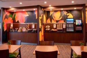 a restaurant with tables and chairs and a counter at Fairfield Inn & Suites By Marriott Ann Arbor Ypsilanti in Ypsilanti