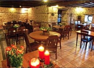 a restaurant with wooden tables and chairs and candles at Vergoula's Mansion in Kastoria