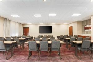 a conference room with tables and chairs and a screen at Courtyard Tampa Brandon in Tampa