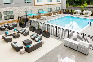 una imagen de una piscina en un hotel con sofás y sillas en Element Nashville Airport en Nashville