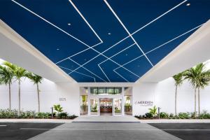 Avon ParkにあるLe Méridien Dania Beach at Fort Lauderdale Airportのヤシの木が植えられた青い天井の建物