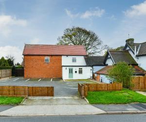 a brick house with a fence in front of it at Rooms at Rolleston in Rolleston