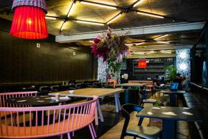 a dining room with tables and chairs and lights at Hallmark Apartment Urban City Stay in Johannesburg