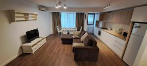 a living room with a couch and a kitchen with a table at C&Y Zev Apartments in Mamaia +23 photos