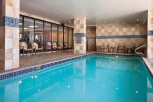 a pool in a hotel with chairs and tables at Courtyard Austin Downtown/Convention Center in Austin