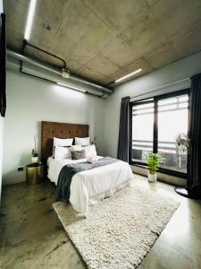 een slaapkamer met een groot bed en een groot raam bij Hallmark Apartment Urban City Stay in Johannesburg