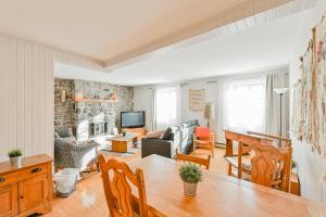 a living room with a table and a living room with a couch at L'Auberge du QG in Laprairie