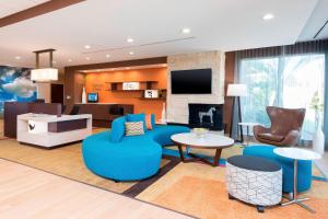 a living room with blue furniture and a fireplace at Fairfield Inn & Suites by Marriott West Monroe in West Monroe
