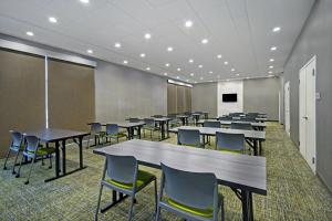 SpringHill Suites by Marriott Hartford Cromwell في كرومويل: قاعة اجتماعات مع طاولات وكراسي وشاشة