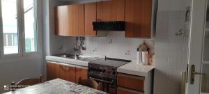 eine Küche mit Holzschränken, einem Herd und einer Spüle in der Unterkunft ViaRoma60_CasaVacanze in Ospedaletti