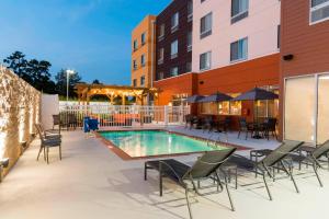 um pátio com uma piscina, mesas e cadeiras em Fairfield Inn & Suites by Marriott West Monroe em West Monroe