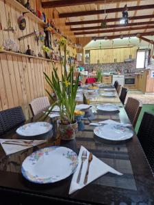 a long table with plates and utensils on it at Casa bunicilor din Leresti in Voineşti