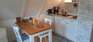 a small kitchen with a wooden table and a sink at Cosy Home in Scharbeutz
