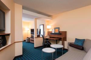 Fairfield Inn and Suites by Marriott Chicago St. Charles في سانت تشارليز: غرفة في الفندق مع أريكة ومكتب