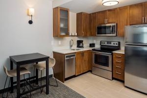 a kitchen with wooden cabinets and stainless steel appliances at Residence Inn by Marriott Charleston Summerville in Summerville