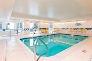 uma piscina num quarto de hotel com cadeiras amarelas em Fairfield Inn and Suites by Marriott Chicago St. Charles em Saint Charles