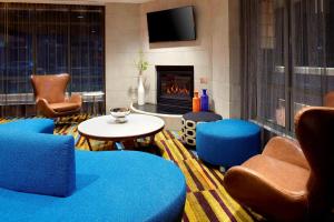 a living room with blue chairs and a fireplace at Fairfield by Marriott Inn & Suites Wheeling at The Highlands in Triadelphia