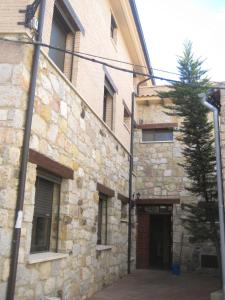 kamienny budynek z drzwiami i drzewem obok niego w obiekcie Hostal Guarni w mieście Barahona