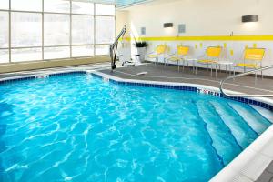 a swimming pool in a hotel room with yellow chairs at Fairfield by Marriott Inn & Suites Wheeling at The Highlands in Triadelphia