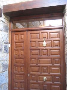 a wooden door with a window in a stone wall at Hostal Guarni in Barahona