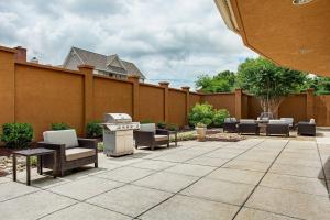 eine Terrasse mit Stühlen, einem Grill und einem Zaun in der Unterkunft Courtyard Knoxville Cedar Bluff in Knoxville