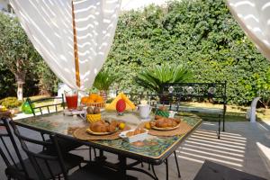 una mesa con pan y fruta en el patio en Villa Cinzia en Mondello