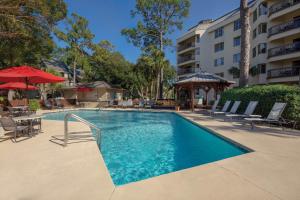 a swimming pool with chairs and a hotel at Marriott's Heritage Club in Hilton Head Island