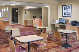 a cafeteria with tables and chairs and a counter at TownePlace Suites by Marriott Lake Jackson Clute in Clute