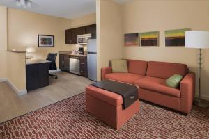 a living room with a couch and a kitchen at TownePlace Suites by Marriott Lake Jackson Clute in Clute