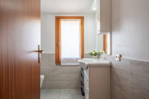 een badkamer met een wastafel, een toilet en een raam bij Casa Delle Pleiadi in Torre delle Stelle
