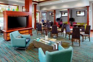 um átrio do hotel com cadeiras, uma televisão e mesas em Residence Inn Tampa Suncoast Parkway at NorthPointe Village em Lutz