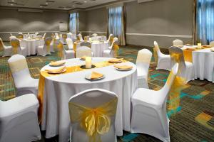 una sala de banquetes con mesas blancas y sillas blancas en Residence Inn Tampa Suncoast Parkway at NorthPointe Village, en Lutz