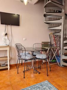 uma sala de jantar com cadeiras e uma mesa e uma televisão em Casina del Puerto em Cudillero