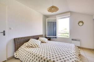 sypialnia z łóżkiem z dwiema poduszkami i oknem w obiekcie Agréable Appartement 3* non loin de l’Océan w mieście Biscarrosse