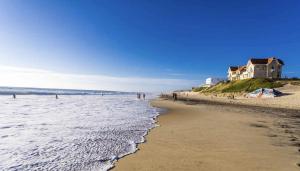 plaża z domem na szczycie wzgórza tuż przy oceanie w obiekcie Agréable Appartement 3* non loin de l’Océan w mieście Biscarrosse +4 zdjęcia