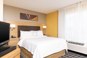 Schlafzimmer mit einem Bett und einem Flachbild-TV in der Unterkunft TownePlace Suites by Marriott East Lansing in East Lansing